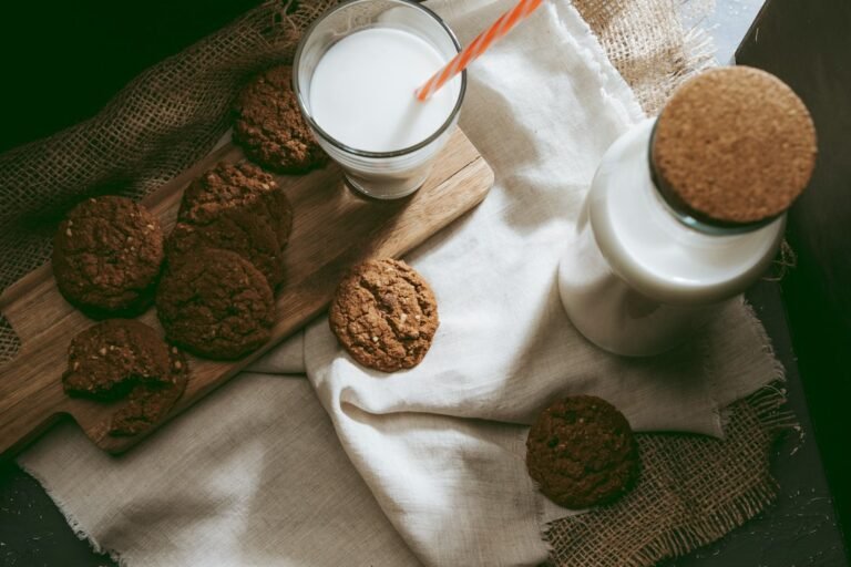 Plant-based milk beside nuts on a kitchen table