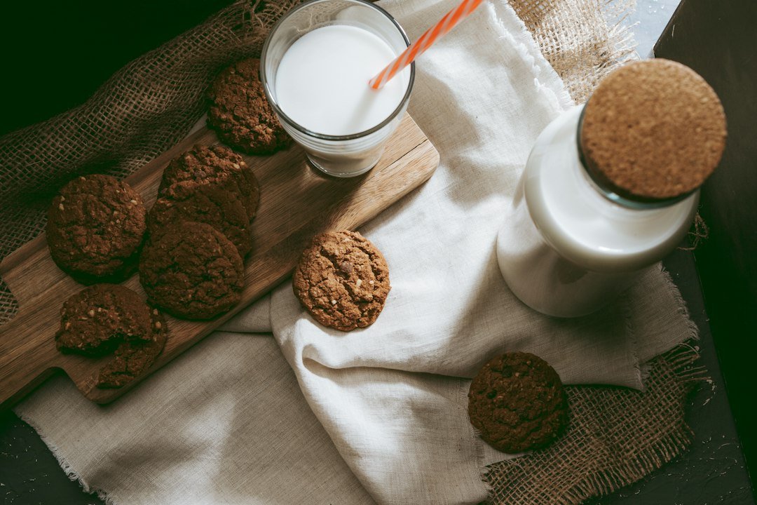 Plant-based milk beside nuts on a kitchen table