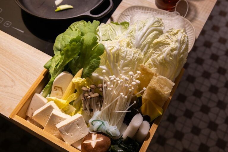 Fresh vegetables and tofu arranged in a wooden tray