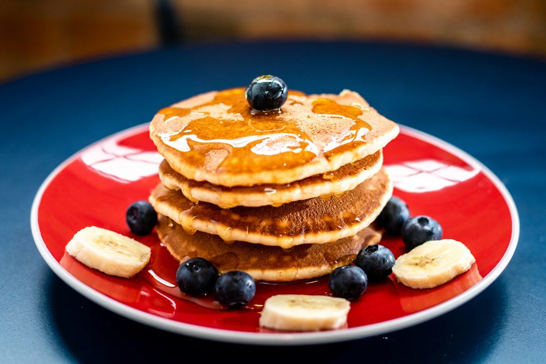 Stack of pancakes with berries and maple syrup