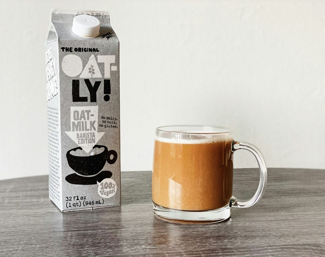 Oat milk latte in a coffee cup, for barista and regular oat milk comparison